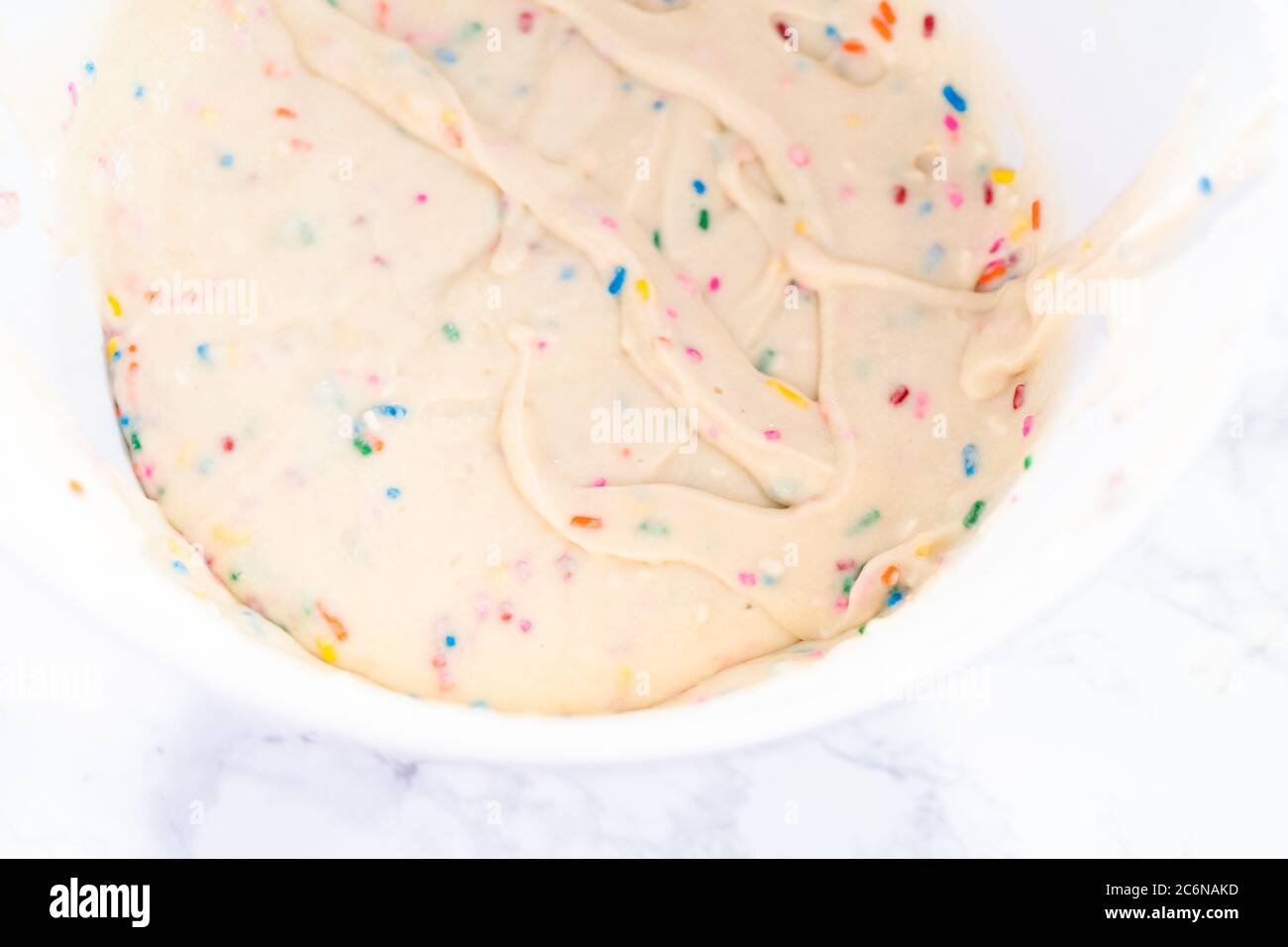 Mixing ingredients to bake birthday funfetti cake with colorful