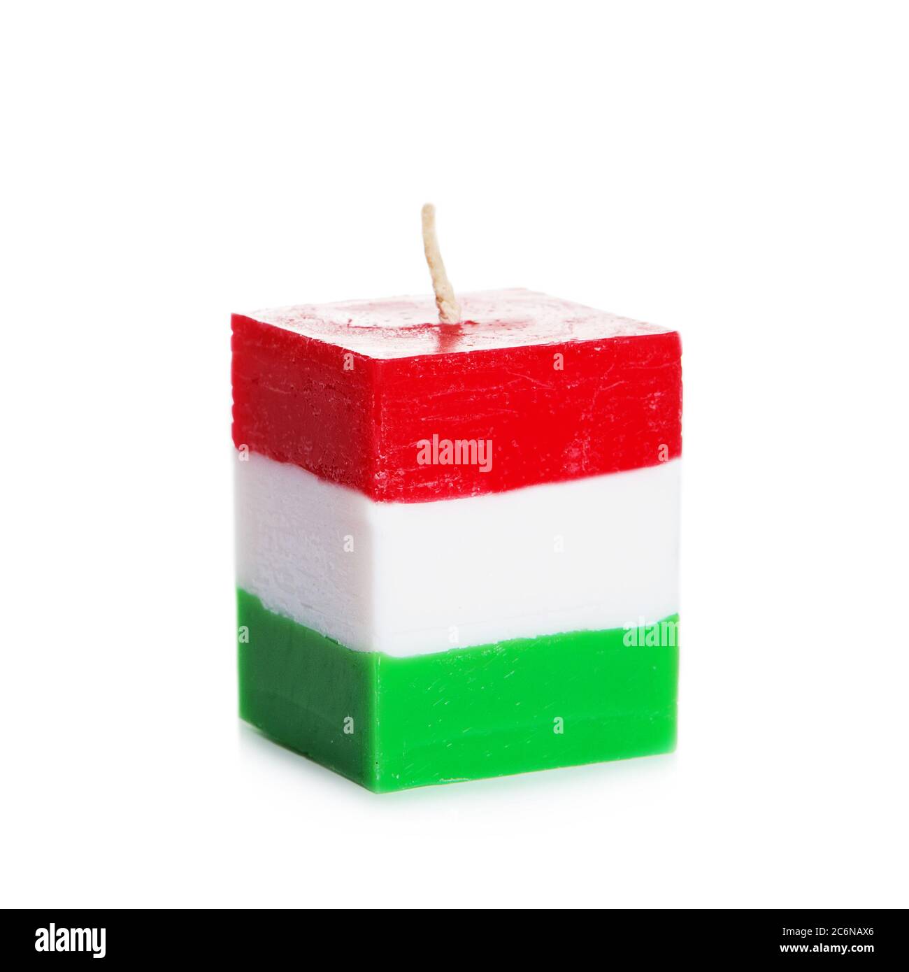 Decorative Handmade candle isolated on white background. Cube-shaped souvenir candle as Hungarian state flag and country symbol. Rectangular cube bloc Stock Photo
