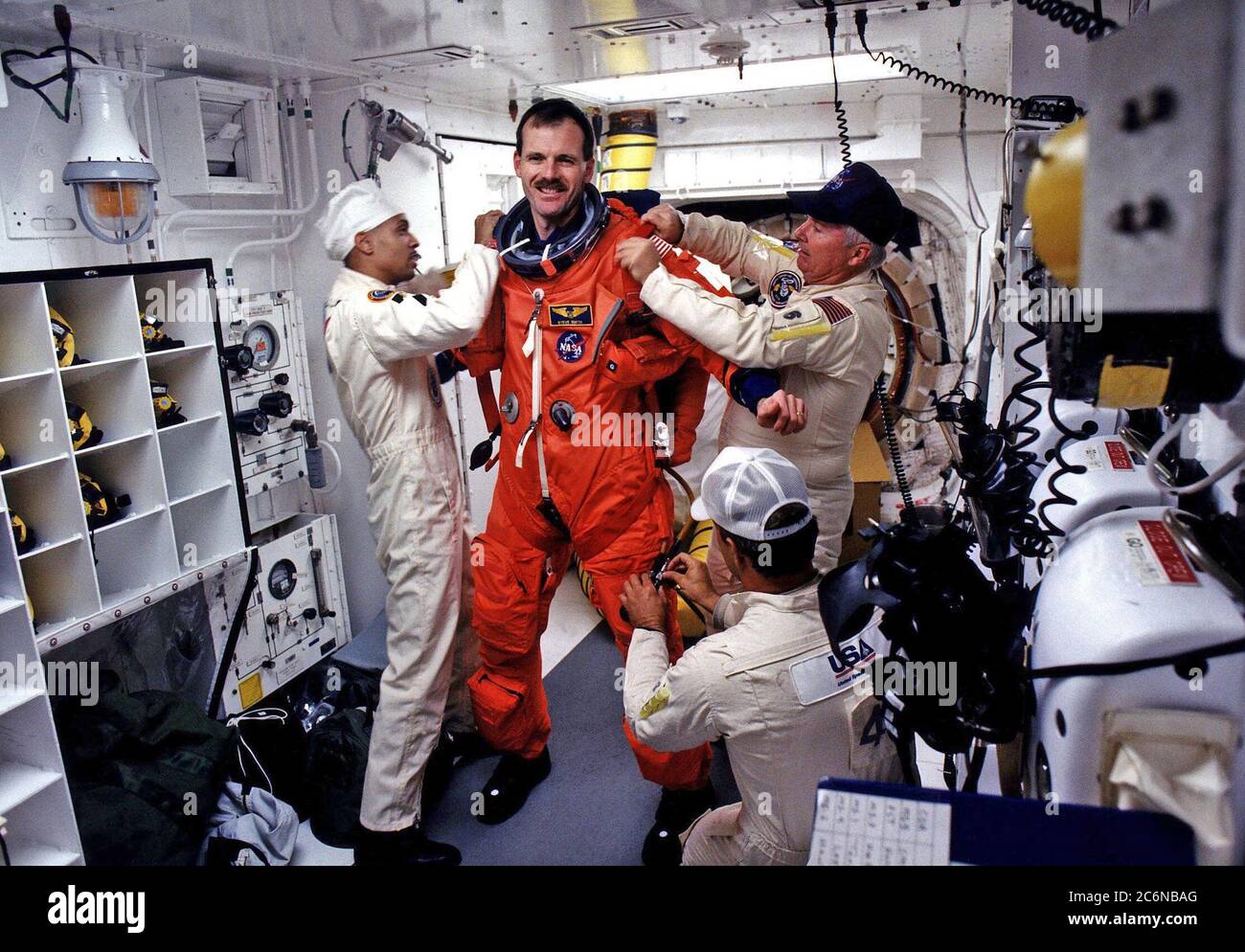 STS-82 Mission Specialist Steven L. Smith prepares to enter the Space Shuttle Discovery at Launch Pad 39A, with the assistance of white room closeout crew members Dave Law, in front; Carlous Gillis, at left; and James Davis Stock Photo