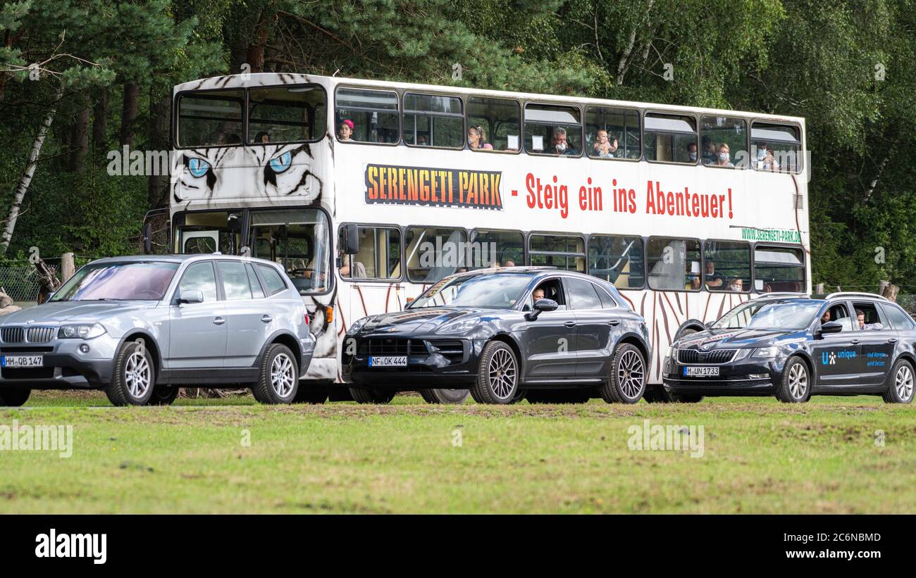 11 July 2020, Lower Saxony, Hodenhagen: Visitor vehicles drive in the Serengeti-Park Hodenhagen in front of a bus of the park. (to dpa 'How business has started again in the amusement parks in Lower Saxony'). Photo: Mohssen Assanimoghaddam/dpa Stock Photo