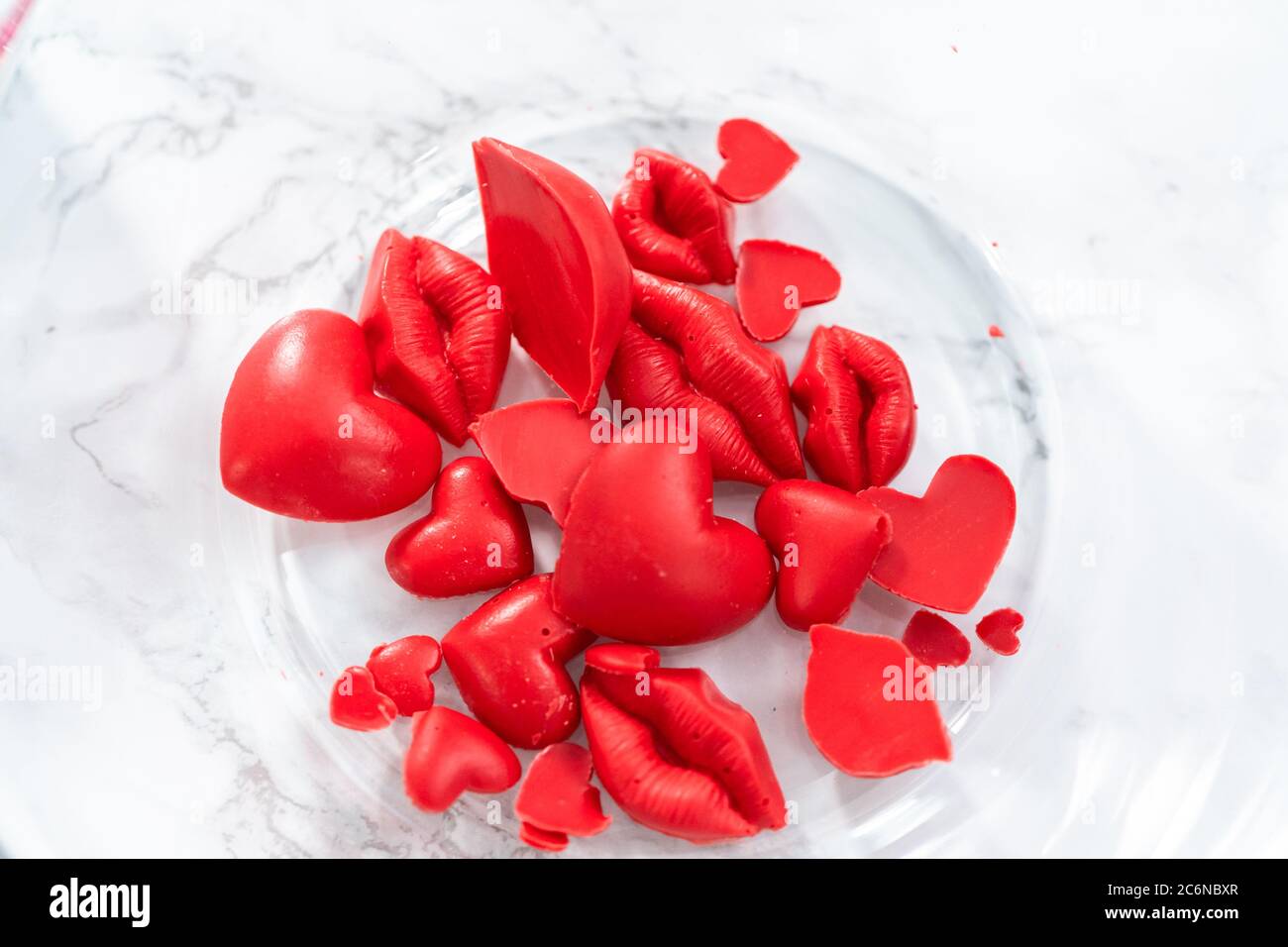 Making hear and kiss shaped chocolate molds with red candy melts Stock