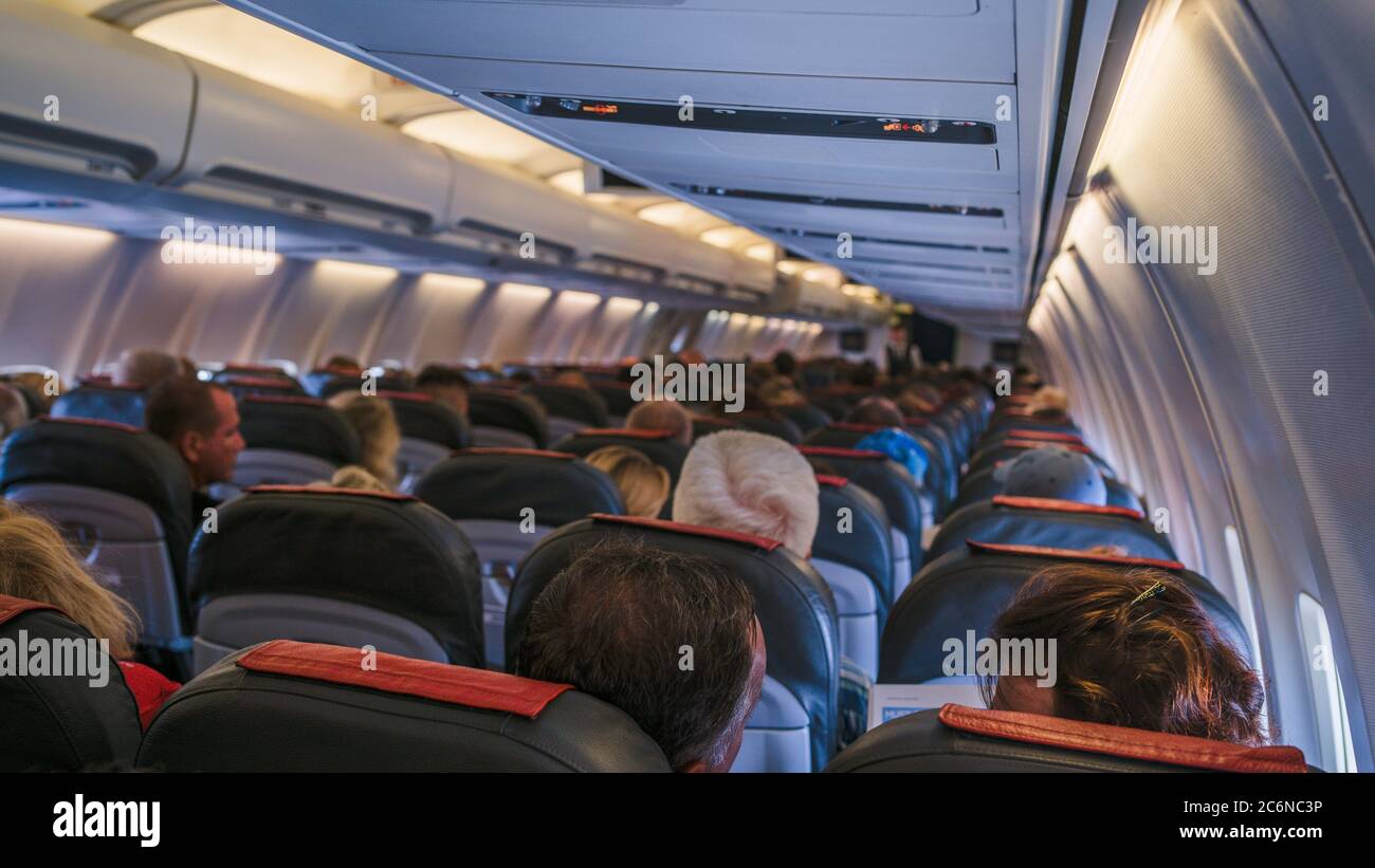 Moscow, Russia December 18, 2019: The rear view of the many people on the plane. Interior of airplane with passengers, sitting on seats. The concept Stock Photo
