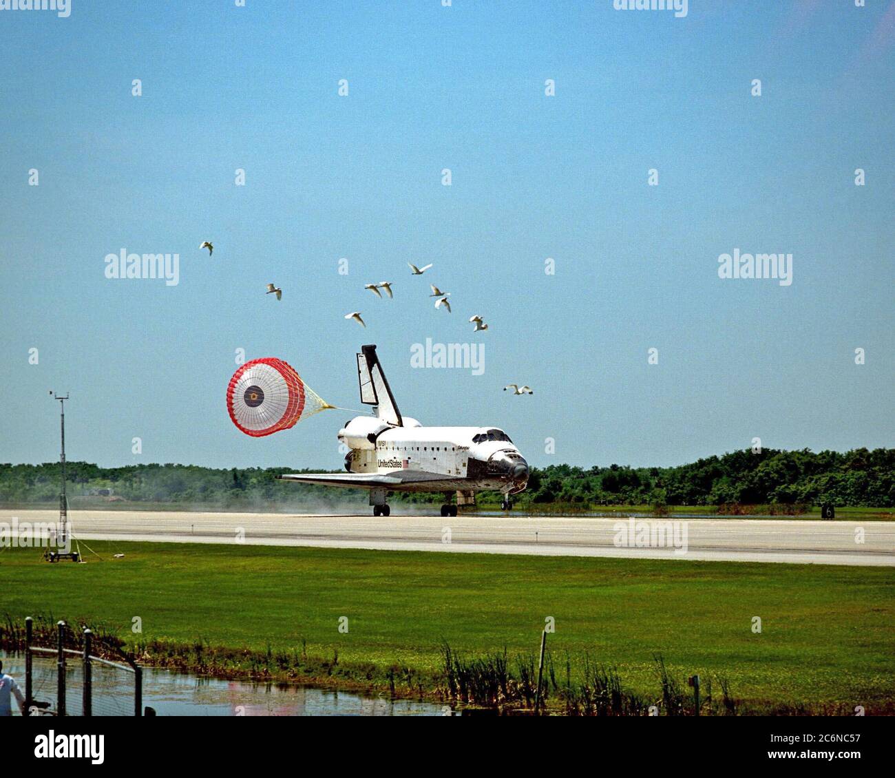 A flock of birds takes flight as the orbiter Columbia, with its drag chute deployed, touches down on Runway 33 of KSC's Shuttle Landing Facility to complete the nearly 16-day STS-90 mission. Main gear touchdown was at 12:08:59 p.m. EDT on May 3, 1998, landing on orbit 256 of the mission. The wheels stopped at 12:09:58 EDT, completing a total mission time of 15 days, 21 hours, 50 minutes and 58 seconds. Stock Photo