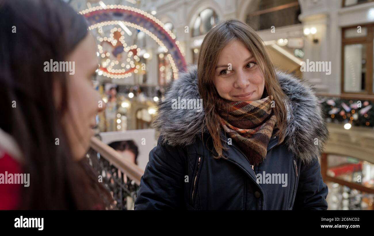 The meeting of the girlfriends. Two women are discussing something in a shopping center. Stock Photo