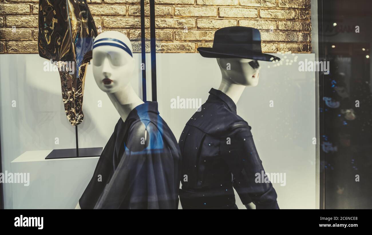 A mannequin stands in the window of a clothing store. Clothing store concept - mannequins in a display window Stock Photo