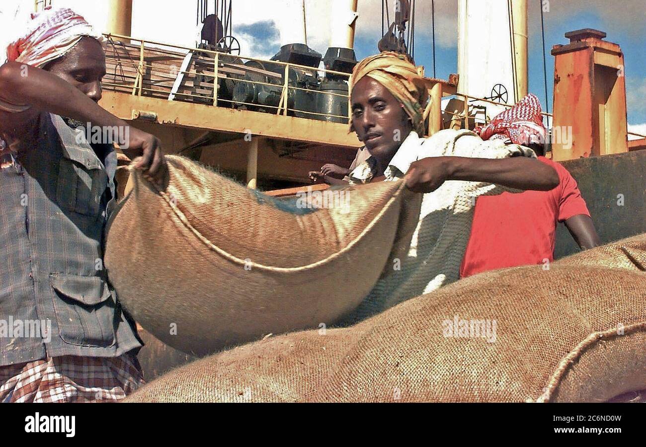 1993 - Somali workers unload a ship carrying sacks of wheat donated by the European communities on the port of Mogadishu, Somalia.  This mission is in support of Operation Restore Hope. Stock Photo