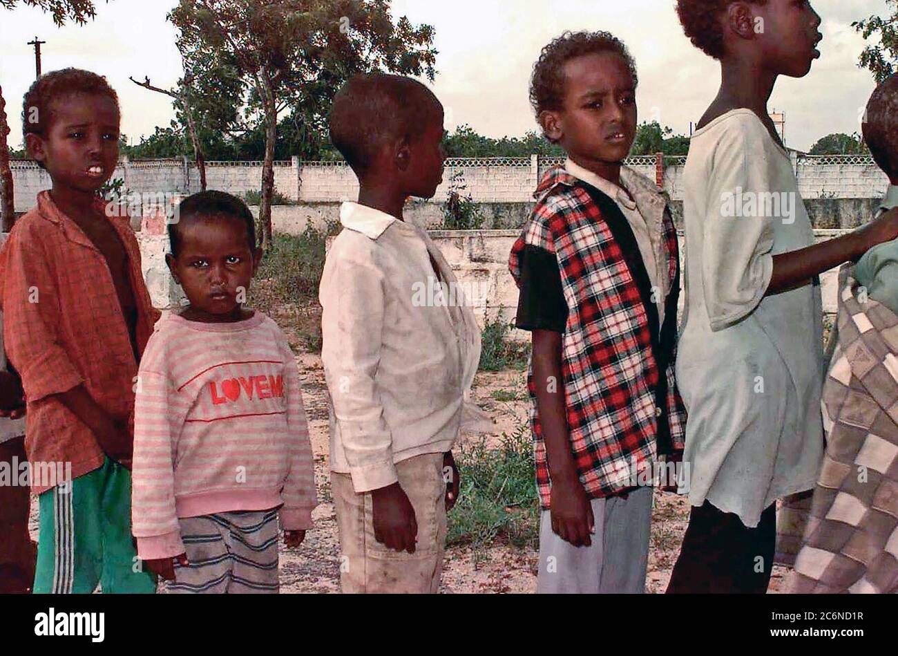 Six Somali boys wait in line patiently at an orphanage where US Navy medical personnel (not shown) were providing checkups for the children.  The orphanage is just outside of Mogadishu.  US Navy and Air Force medical personnel met up with a civilian care group (not shown) to assist in giving check-ups to the children in the orphanage.  Once word got out that there was a medical team in town, women from the local area started bringing their children (not shown).  The team tried to see as many as possible, but supplies quickly ran out.  This mission is in direct support of Operation Restore Hope Stock Photo