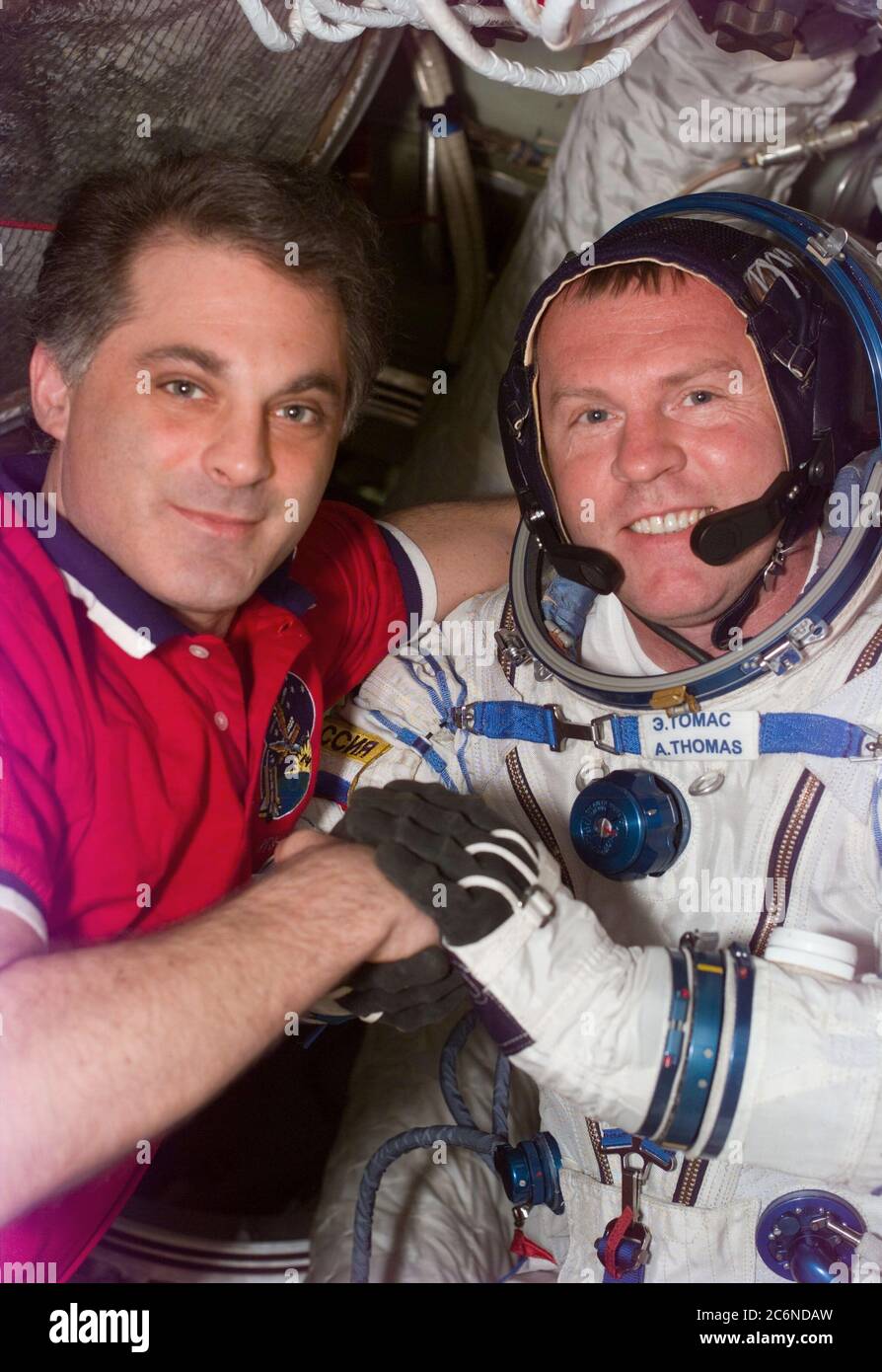 (26 Jan 1998) --- This Electronic Still Camera (ESC) image shows astronauts David A. Wolf and Andrew S. W. Thomas embracing, after Thomas' second Russian Sokol spacesuit test, onboard the Russian Mir Space Station.  Upon Thomas' arrival to Mir he had problems with his Sokol suit, however, following suit modifications the suit fit properly.  Thomas, now replacing Wolf as cosmonaut guest researcher, will be the last American astronaut to serve a tour onboard Mir.  This ESC view was taken on January 26, 1998, at 12:56:21 MET. Stock Photo
