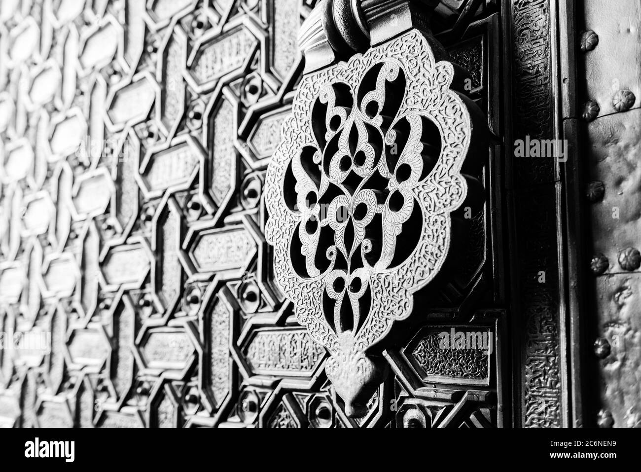 Detail of an islamic door knocker and ornaments outside one of the main entrance gates to the Cathedral of Seville, Spain. Shallow DOF, toned. Stock Photo