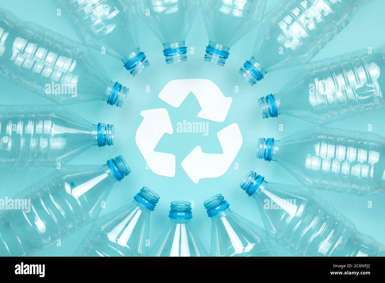 Horizontal color image with an overhead view of a clear plastic bottles without caps on a blue background. Recycling and environment concept. Stock Photo
