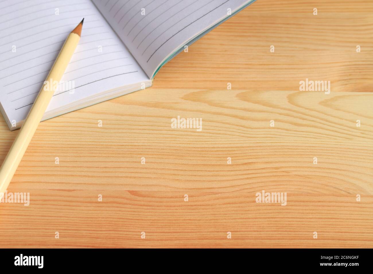 Blank Lined Notebook with a Pencil Isolated on Wooden Table Stock Photo