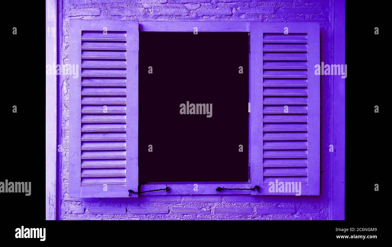 Vivid purple colored wooden window with shutters on brick wall with copy space Stock Photo