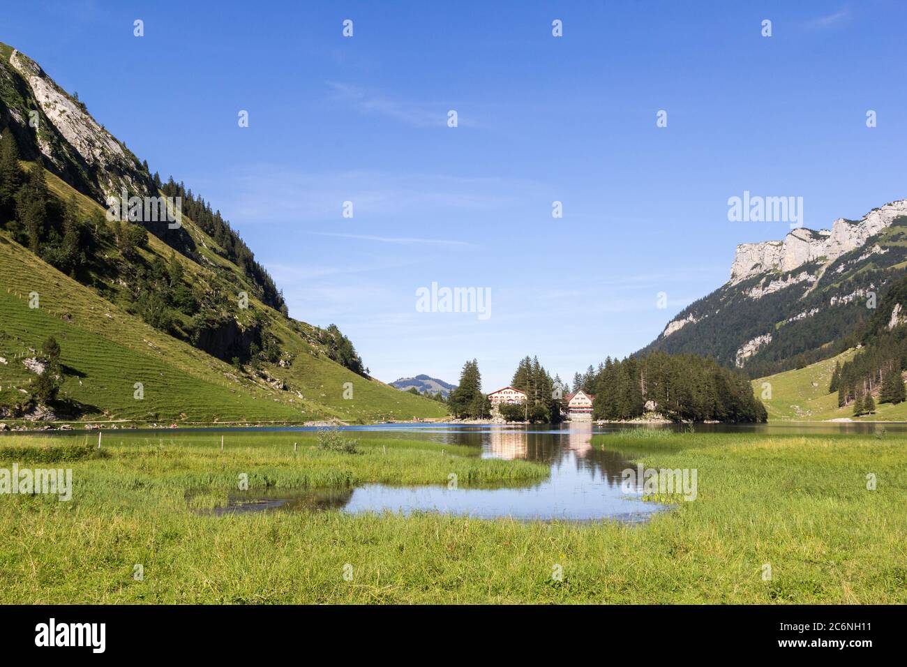 Lake Seealpsee with wetland at the foreground and house reflection in the valley of Ebenalp, Appenzellerland, Switzerland Stock Photo