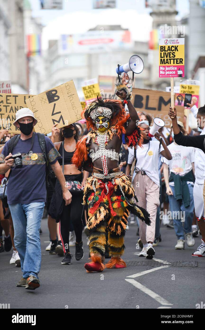 Brighton UK 11th July 2020 - Palaye Seck dressed in traditional  Senegalese costume leads thousands of protesters tin the Black Lives Matter anti racism rally in Brighton today beginning on the seafront before marching through the city centre  . There have been protests throughout America , Britain and other countries since the death of George Floyd while being arrested by police in Minneapolis on May 25th : Credit Simon Dack / Alamy Live News Stock Photo