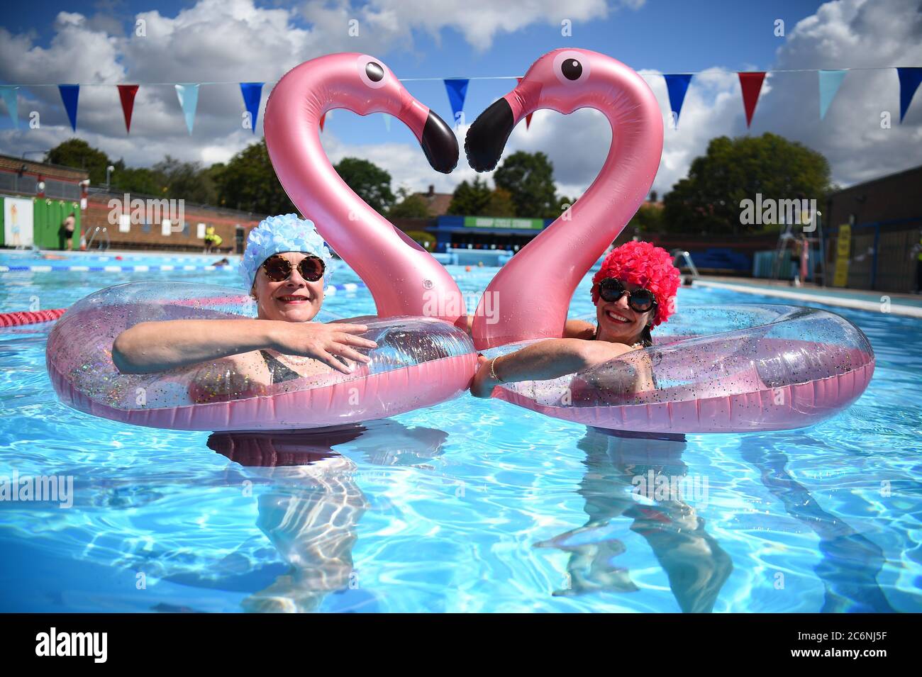 Swimmers Nicola Foster (left), 55, and Jessica Walker, 56, enjoy the water at Charlton Lido & Lifestyle Club in Hornfair Park, London. Outdoor swimming pools are reopening to the public on Saturday as the easing of coronavirus lockdown restrictions continues in England. Stock Photo