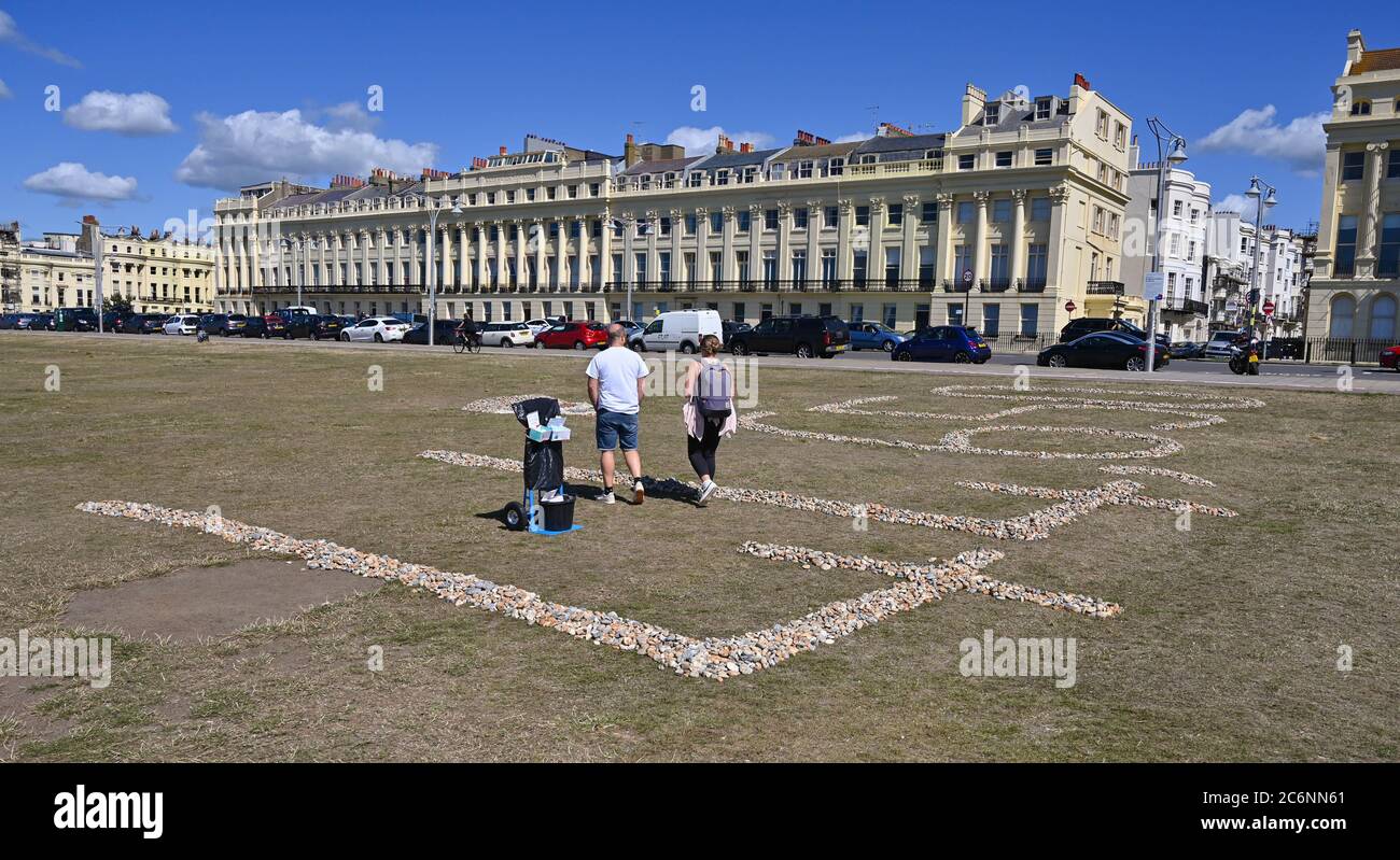 Brighton UK 11th July 2020 - A tribute to those who have died from coronavirus in the UK has been created out of pebbles on Hove Lawns in Brighton .It is a mystery who has created it and it shows the number 44,602 made out of stones which was the number of deaths from COVID-19 in the UK last Wednesday : Credit Simon Dack / Alamy Live News Stock Photo