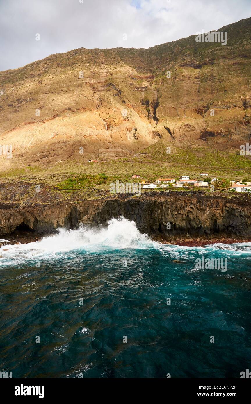 Houses by the sea with Reserva Natural Especial Tibataje cliffs in the back (Las Puntas, La Frontera, El Hierro, Canary Islands, Atlantic sea, Spain) Stock Photo