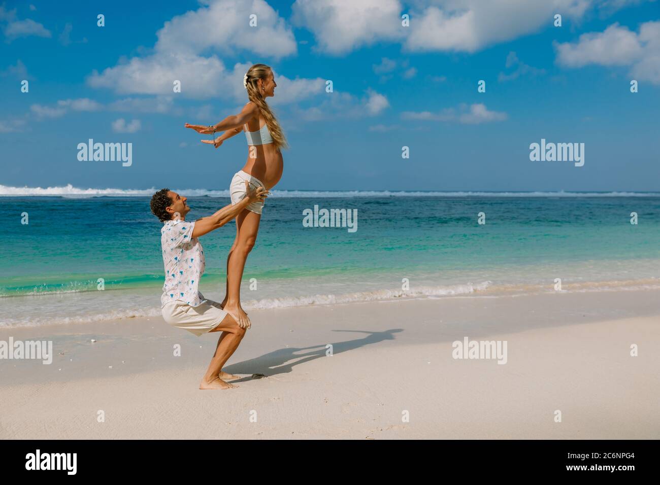 Pregnant woman with husband expecting baby with yoga pose at ocean beach  Stock Photo - Alamy