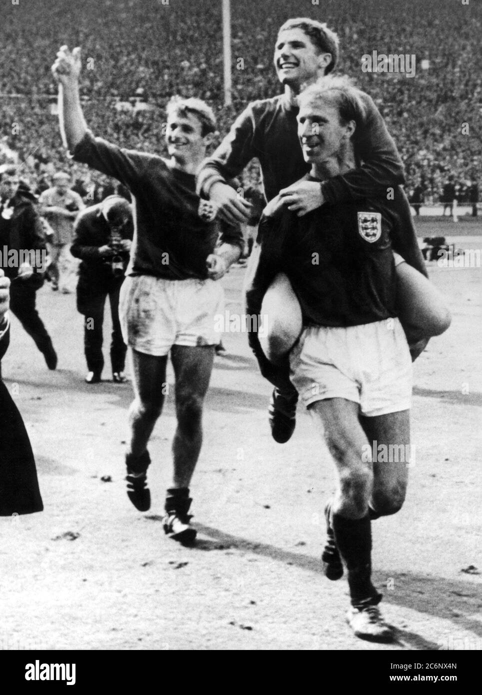 30 July 1966 Wembley Stadium, England. 1966 World Cup Final, Germany versus England.Jack Charlton carries Alan Ball as Roger Hunt (l) follows up the rear after beating Germany 4-2 after extra time is played. Stock Photo