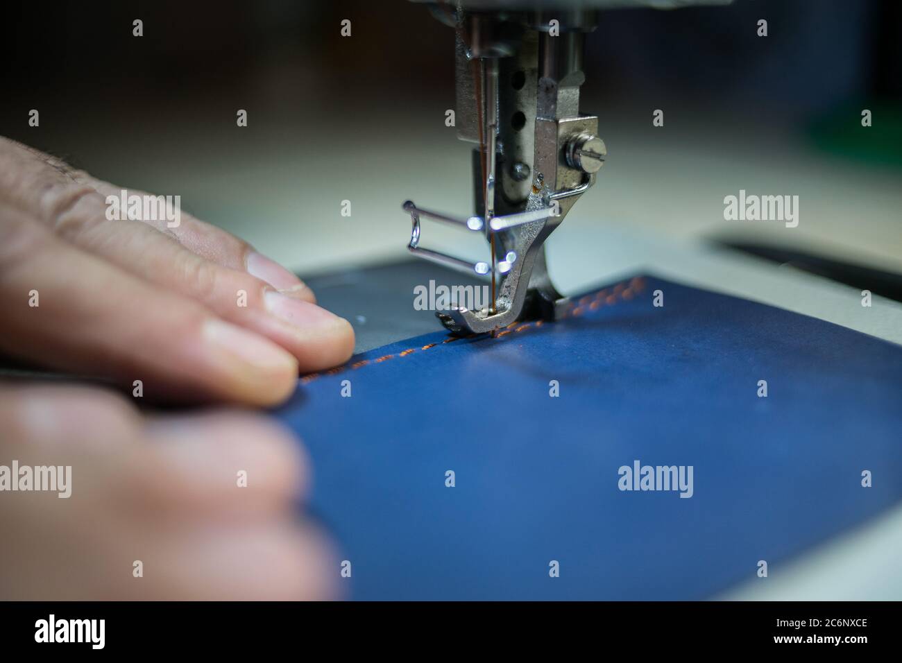 A man sews from leather on a sewing machine. Hands and sewing Stock