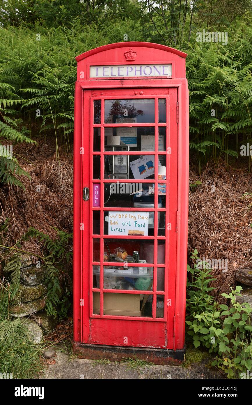 Traditional British red telephone box also being used as a food larder for the local community Stock Photo