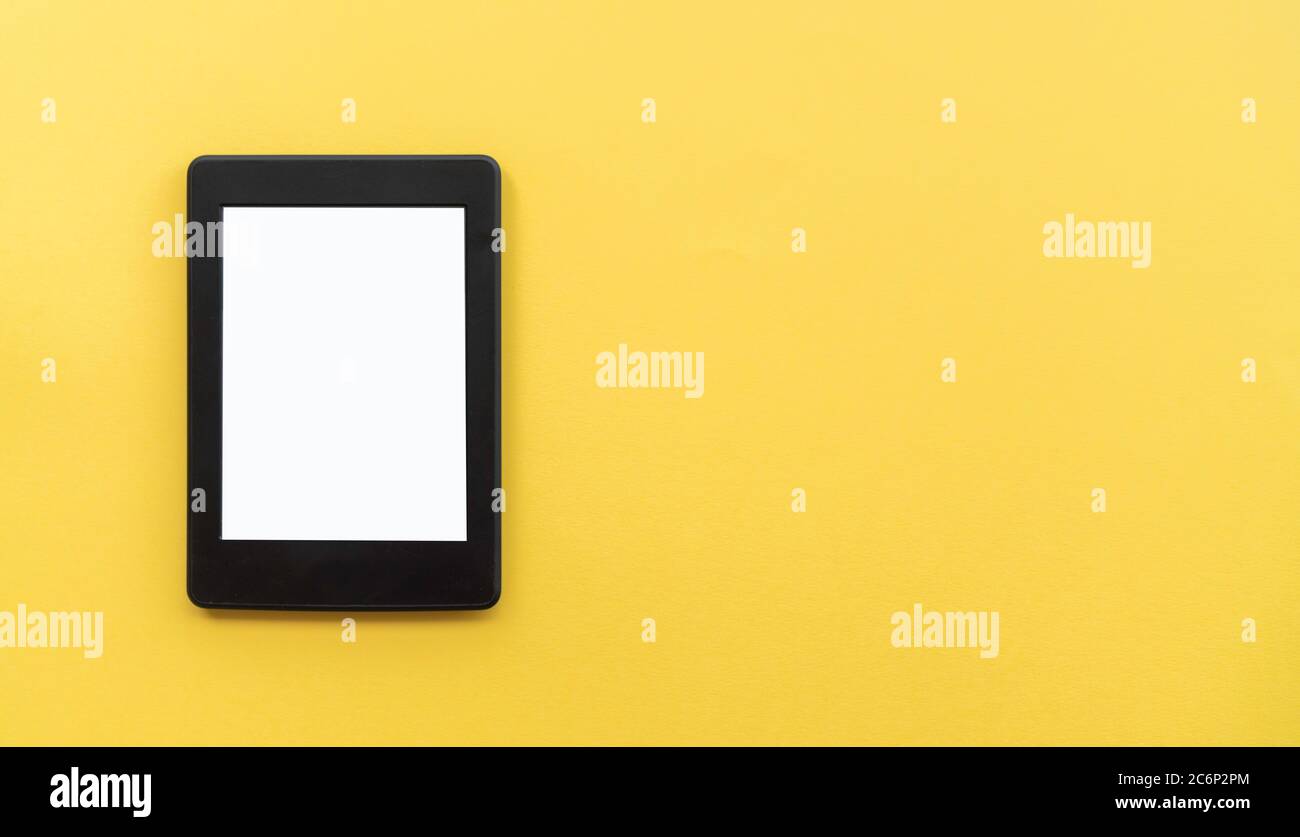 A modern black electronic book with a white blank empty screen on yellow background with empty space Stock Photo