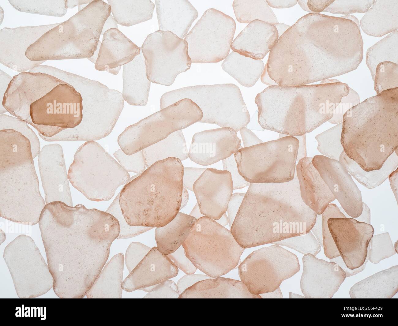 Close-up filling frame of translucent pink sea glass chips on a white background Stock Photo