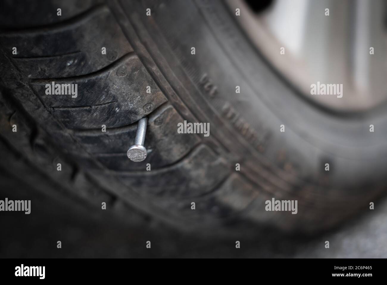 Close up button head needle metal nail stuck to puncture into wheel