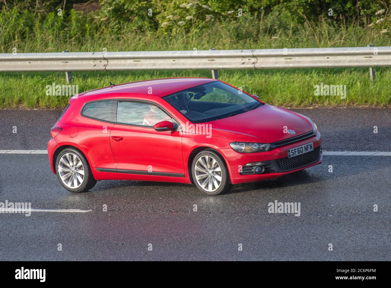 2010 red VW Volkswagen Scirocco GT TDI S-A; Vehicular traffic moving vehicles, cars vehicle on UK wet roads, motors, motoring on the M6 motorway network Stock Photo - Alamy