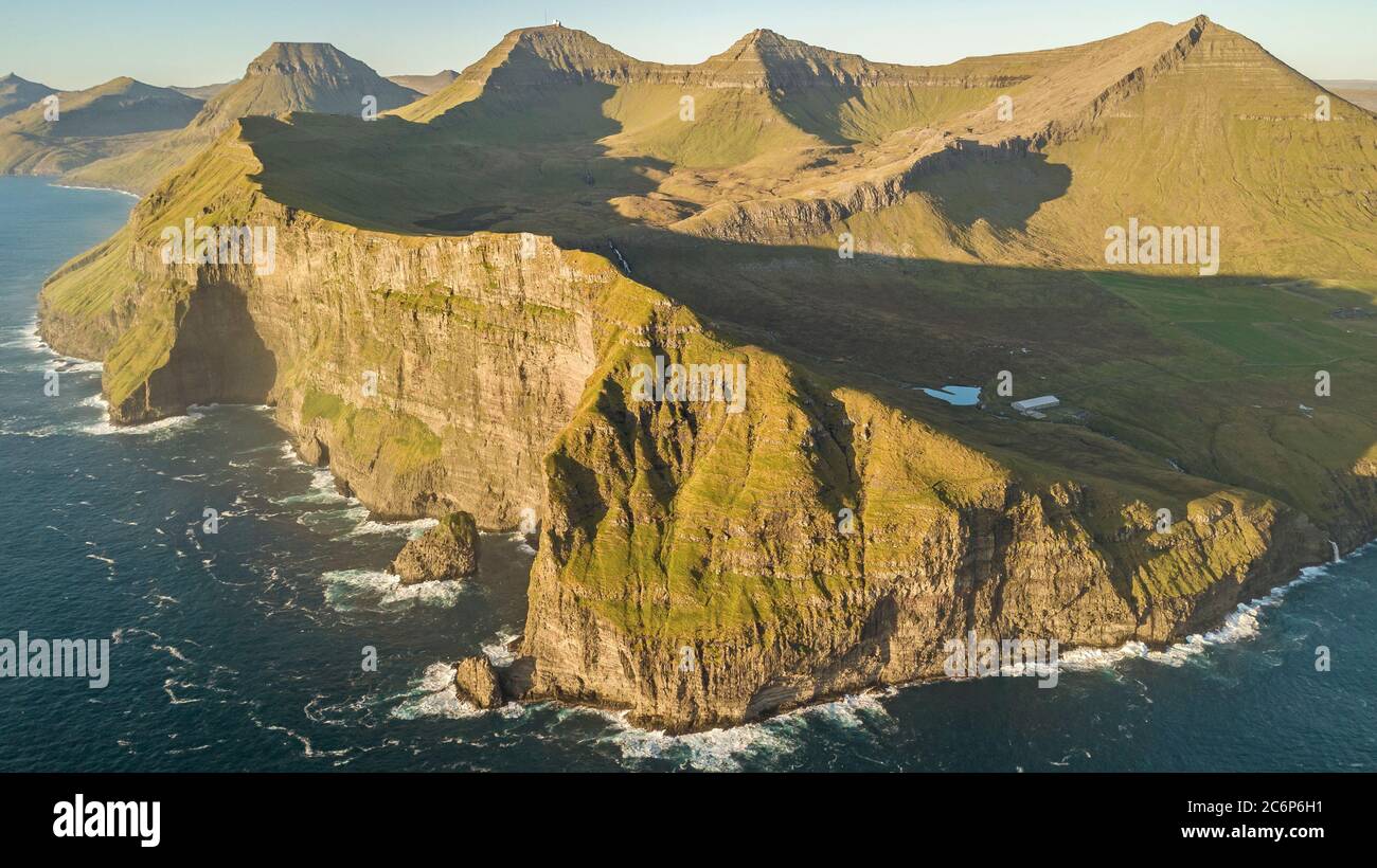 Flying a drone high above the Atlantic Ocean to capture the enormous cliffs of the Faroe Islands at Nordradalur. Stock Photo