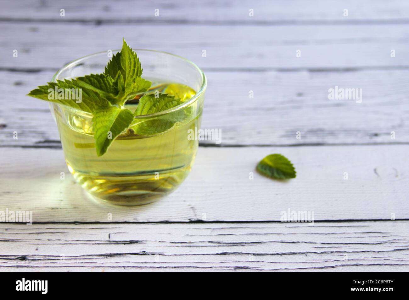 Fresh mint tea concept. Mint tea in transparent cup and one mint leaf