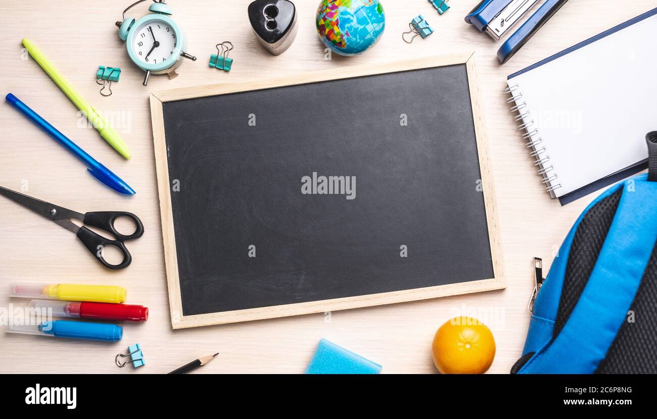 Stationery school supplies around the board. Top view and copy space. Concept of back to school