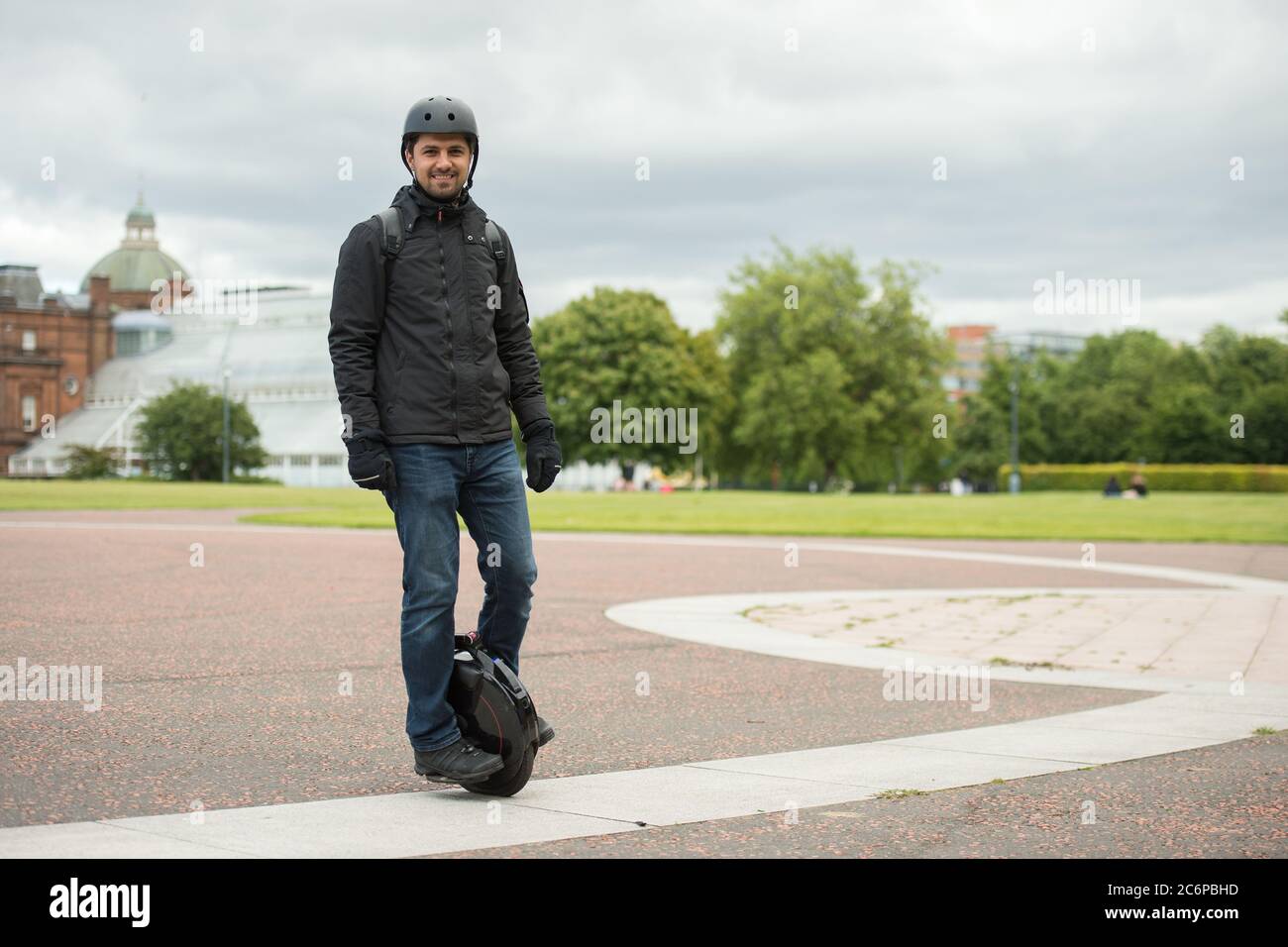 Man wearing surgical mask riding electric unicycle hires stock