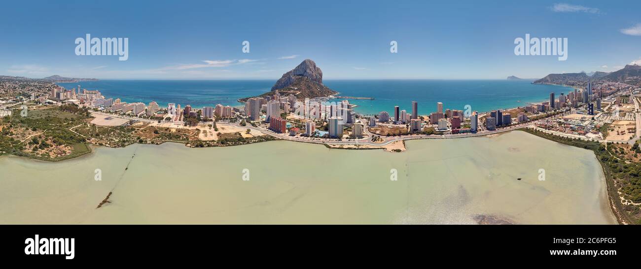 Panoramic wide angle salt lake waterside view Calpe skyline cityscape and Penyal d'Ifac Natural Park. Horizon over Mediterranean Sea, sunny summer day Stock Photo