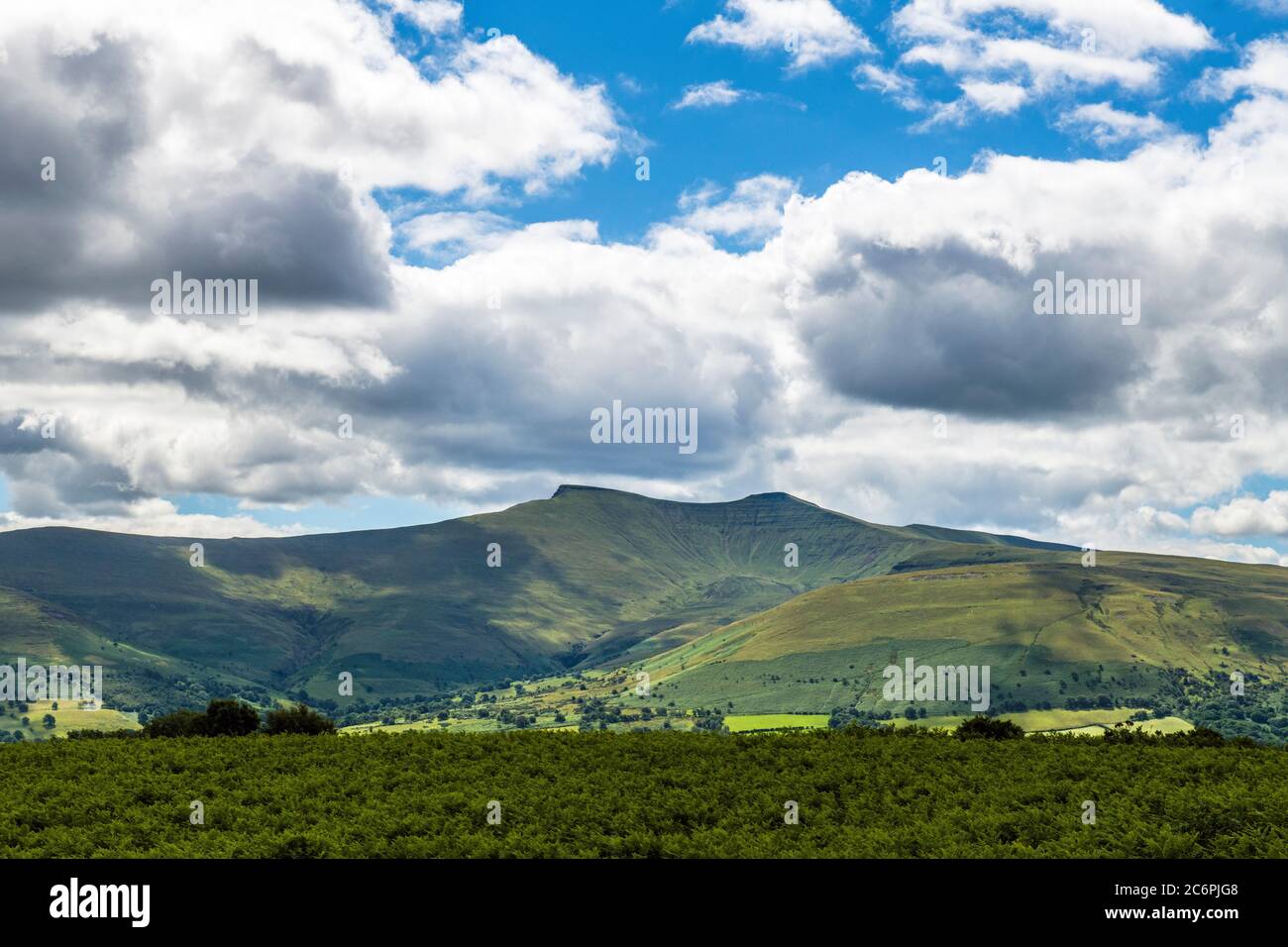 Pen y Fan and Corn Du in the central Brecon Beacons in Powys South Wales on a sunny and cloudy July summer day Photographed from Mynydd Illtud Common. Stock Photo