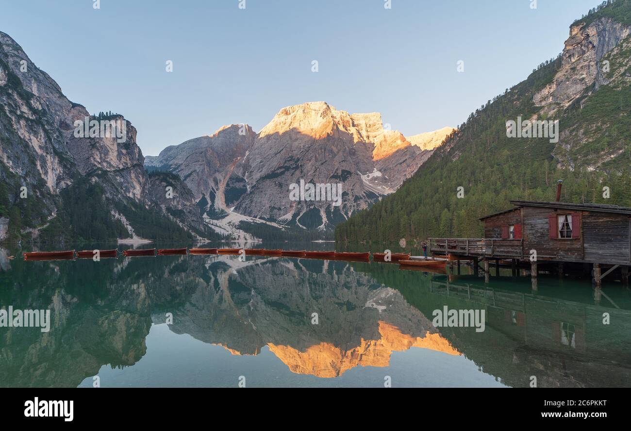 The Seekofel mountains and wooden boats reflected in the waters of Lake Braies at first light in the morning, in the Pragser Wildsee also called Lake Stock Photo