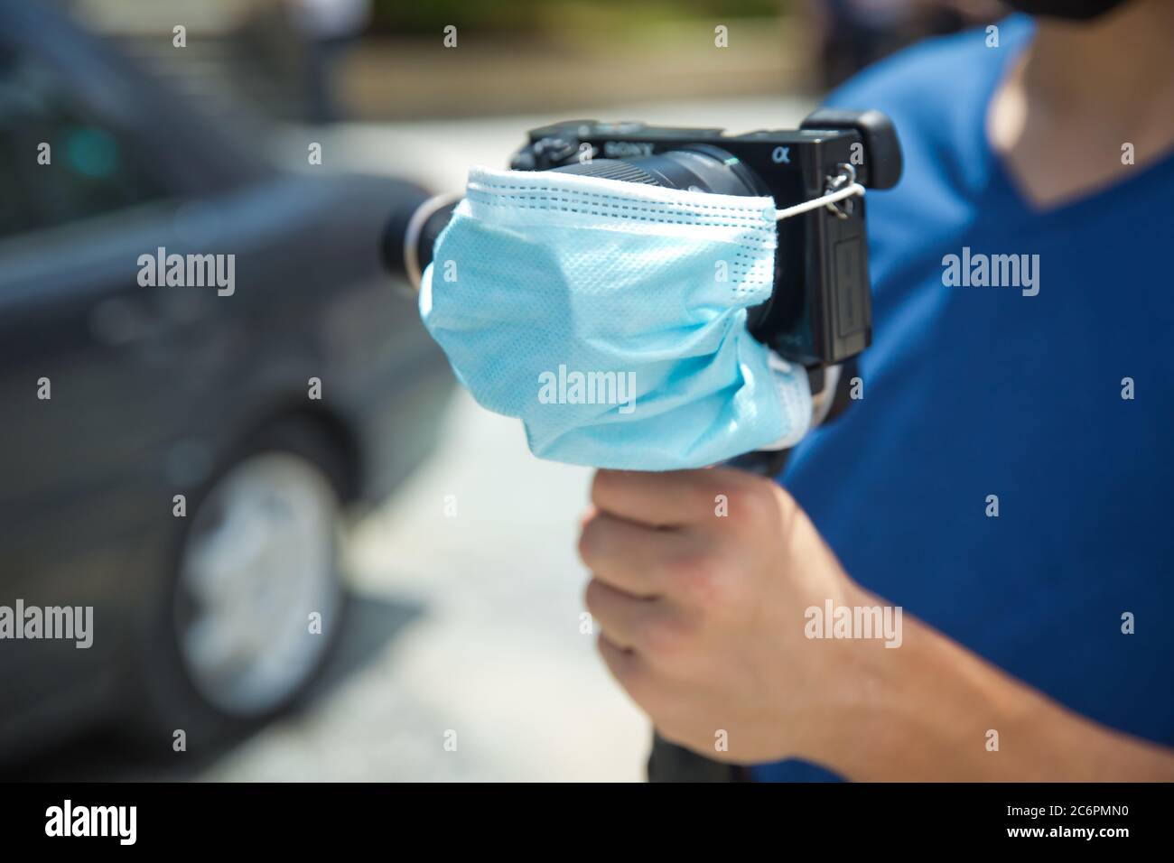 Azerbaijan Baku : 26.06.2020 . Man holding gimbal stabilizer camera outdoor. A blue mask is attached to the camera lens. The camera is protected by CO Stock Photo
