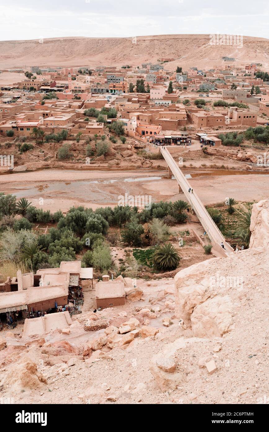 Desert Village viewpoint taken from on top of Ait Benhaddou in Morocco, showing red sandstone buildings above a dry riverbed. Stock Photo