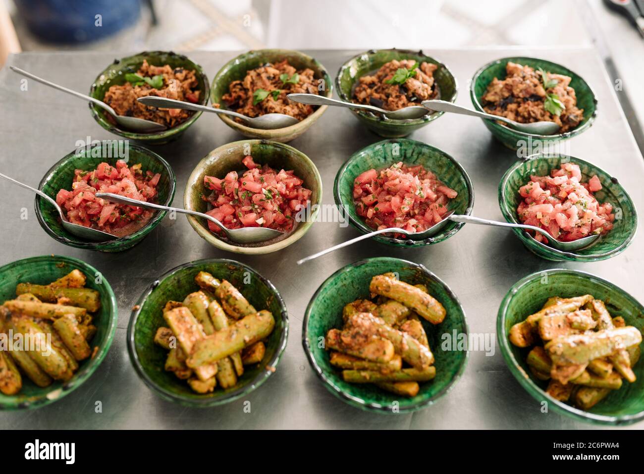 Green Moroccan Serving Bowls Filled with Colorful Spiced Salads and Salsas in Marrakech, Morocco. Stock Photo