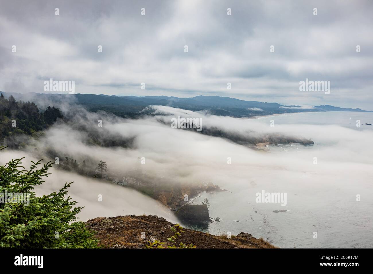 View from Cape Foulweather overlook of fog coming ashore along the Oregon coast Stock Photo