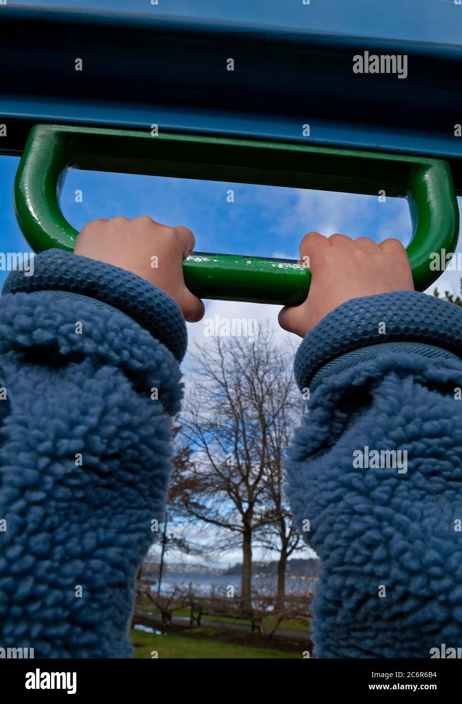 Close-up of child’s hands on playground equipment. Stock Photo