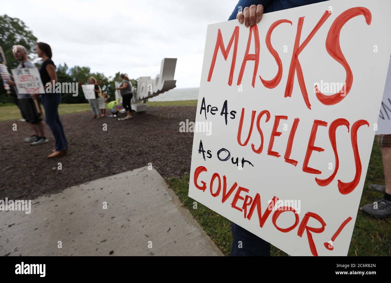 Cleveland, United States. 11th July, 2020. A woman holds signs during a protest against Ohio's face covering order in the wake of the Coronavirus (COVID-19) at Edgewater Park in Cleveland, Ohio on Saturday, July 11, 2020. Photo by Aaron Josefczyk/UPI Credit: UPI/Alamy Live News Stock Photo