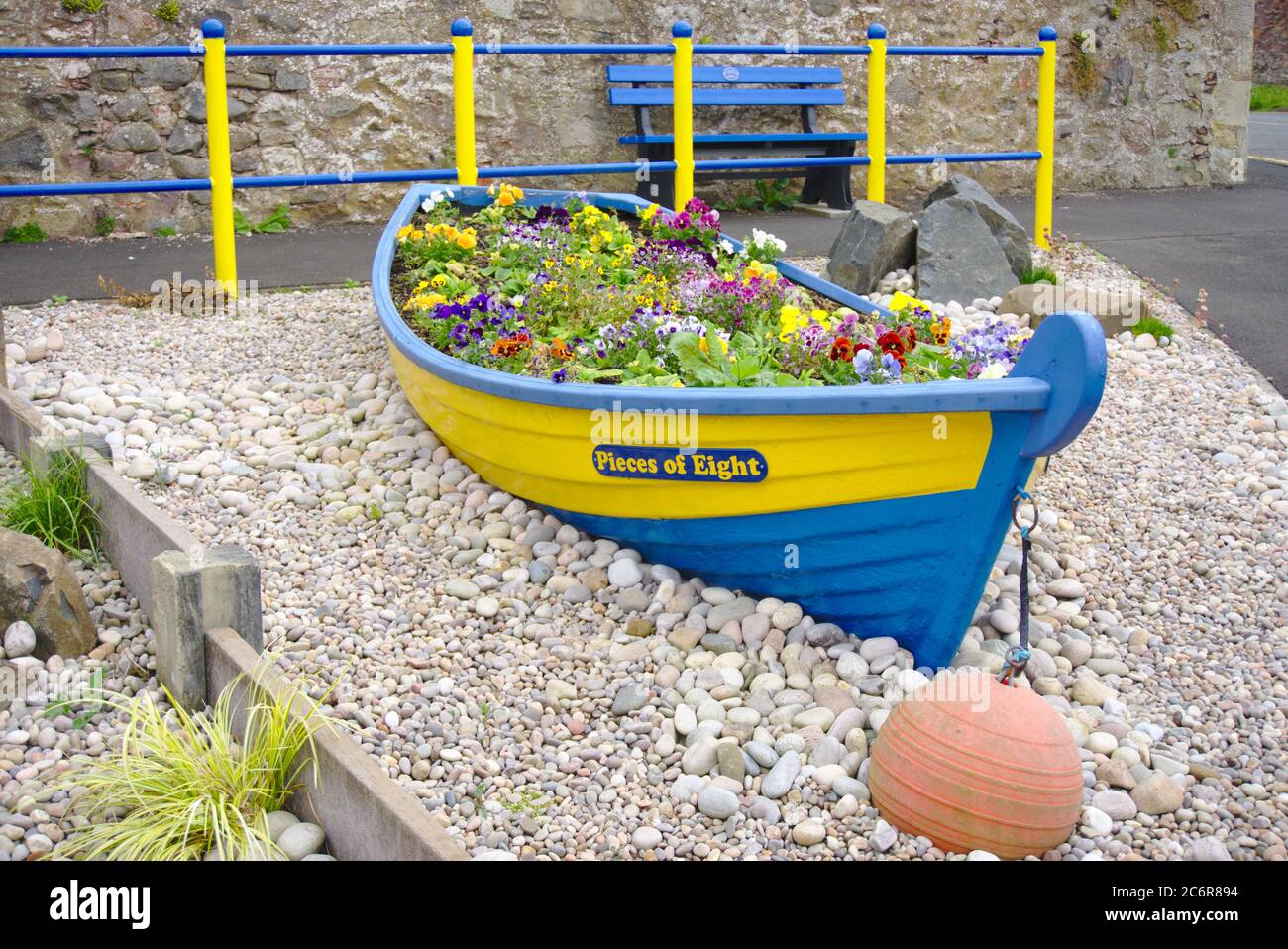 Pieces Of Eight art installation in Coldingham, Berwickshire, Scottish Borders, UK, with flowers arranged in a small boat. Stock Photo
