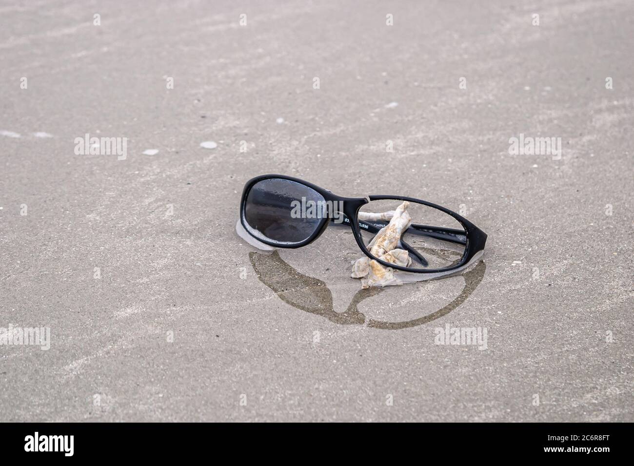 BEACH DEBRIS - CIRCA 2009.  Broken sunglasses,  made of plastic, washed up on a beach Stock Photo