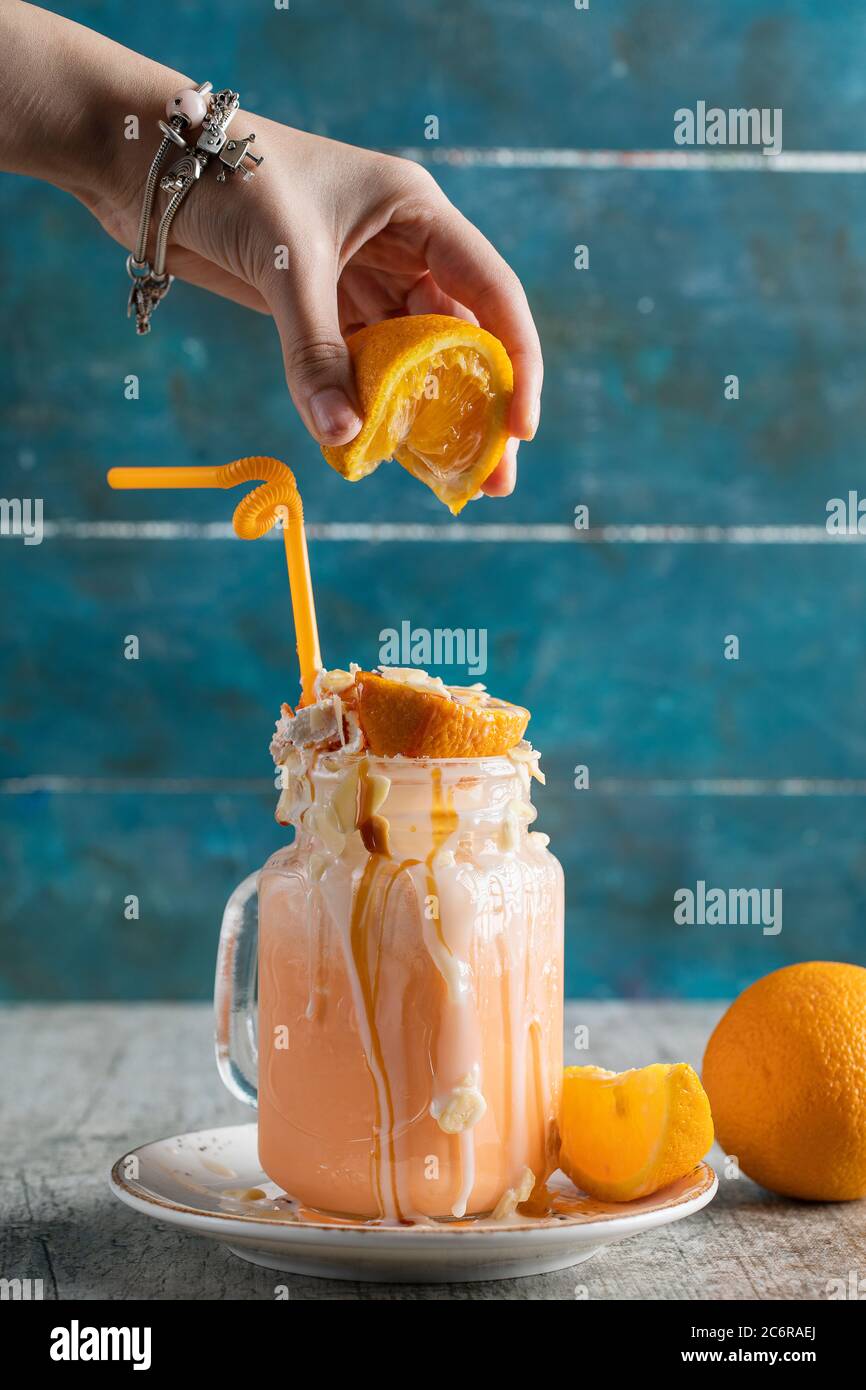 Adding orange juice to milky creamy dessert Stock Photo - Alamy