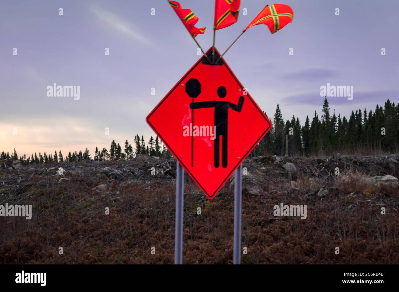 A pictograph in a construction zone. Heads up for vehicle operators that a flag man with a STOP sign is directing traffic on the road ahead, Canada. Stock Photo