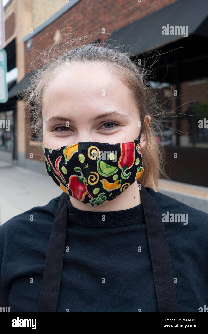 Waitperson wearing a mask from Cafe Latte providing curb service for food delivery. St Paul