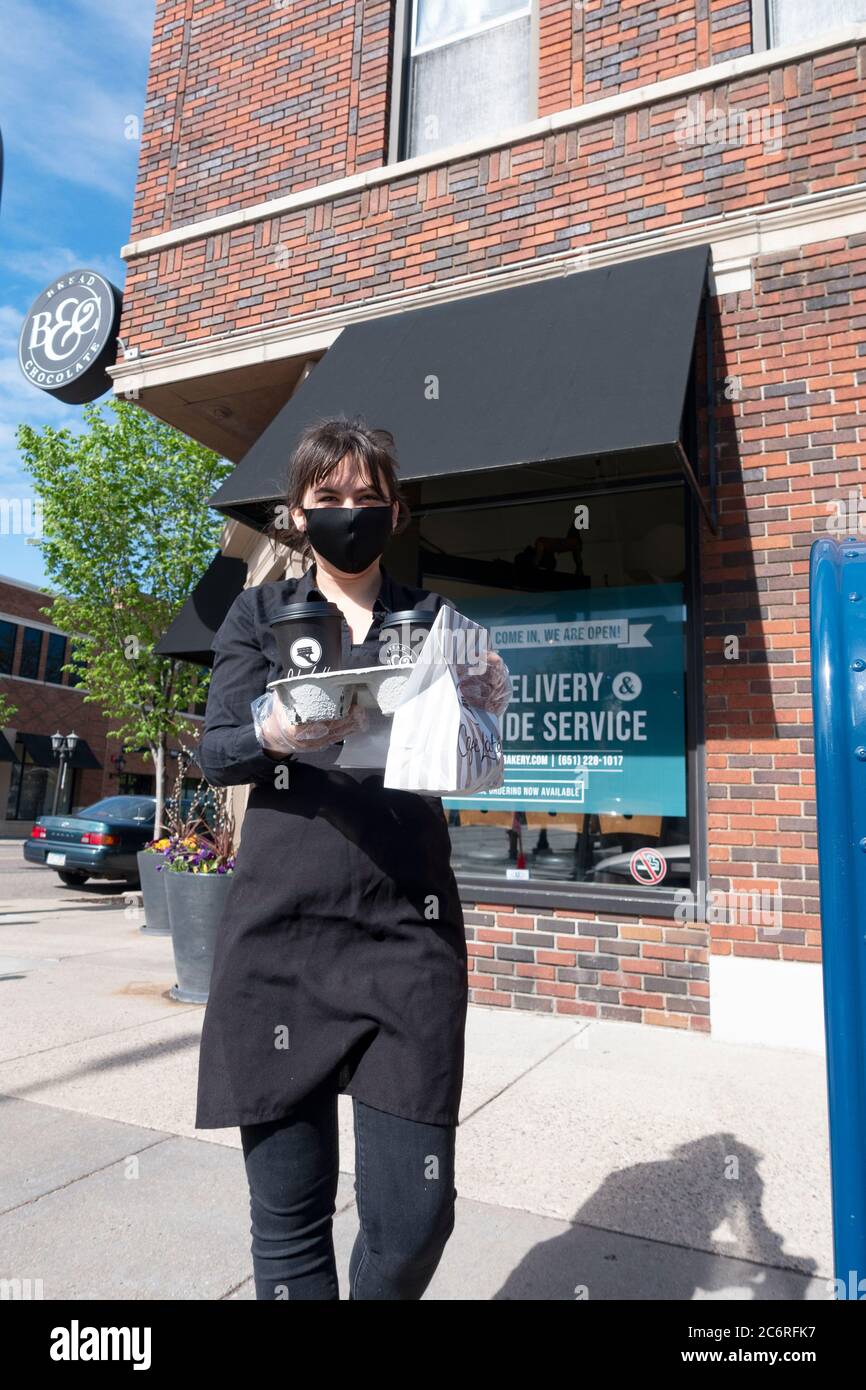 Waitperson delivering food for curbside service at Cafe Latte. St Paul Minnesota MN USA Stock Photo