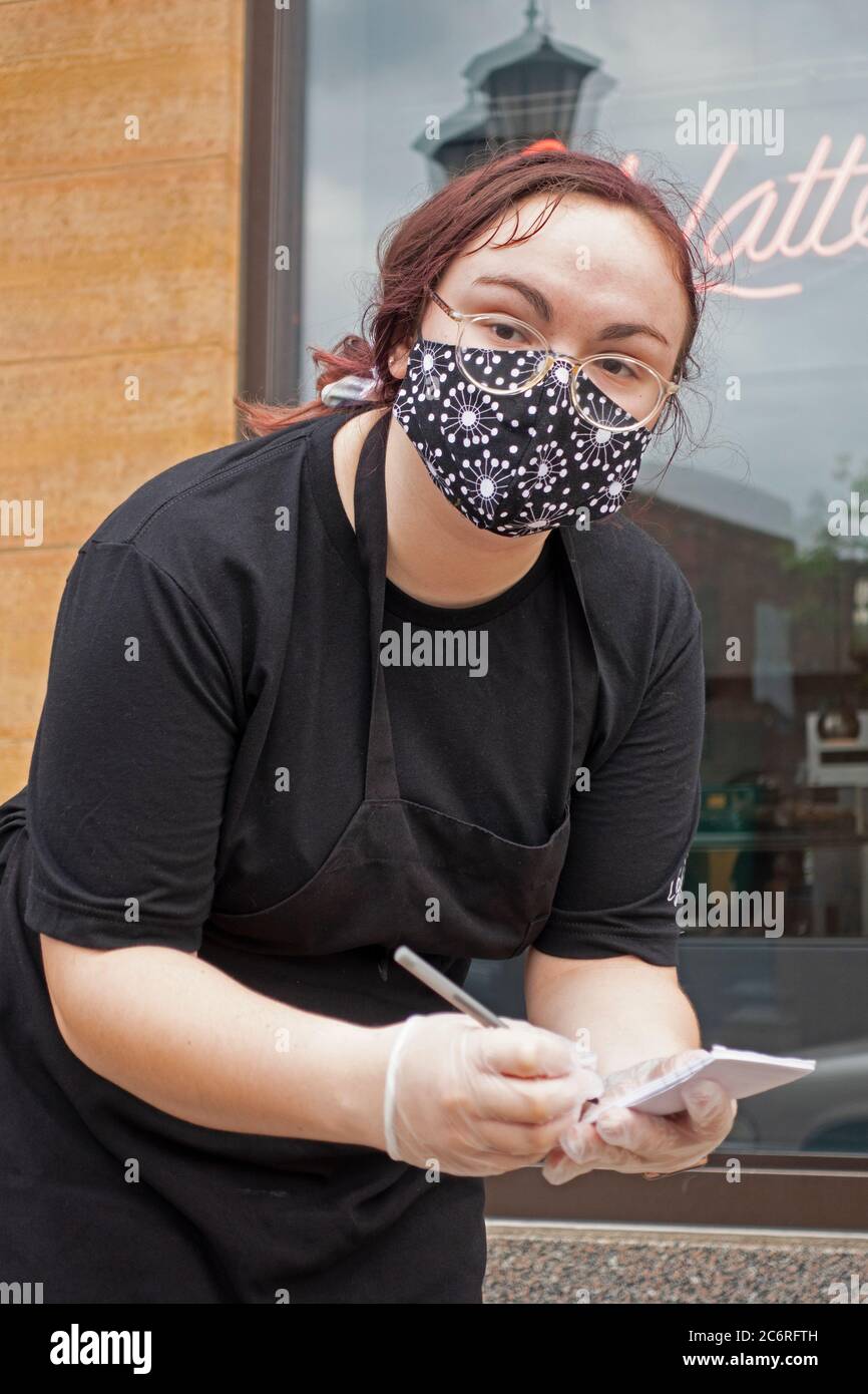 Waitperson writing an order for food at Cafe Latte for curbside delivery and observing social distancing. St Paul Minnesota MN USA Stock Photo
