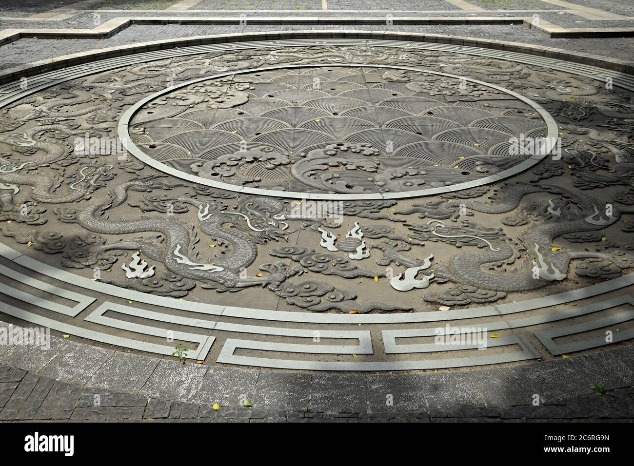 The Nine dragons round stone carving on pavement. Stock Photo